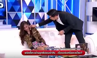 Nữ người mẫu Thippawan "Pui" Chaphupuang sợ hãi khi người dẫn chương trình đưa một chiếc vòng cổ có hình Phật lại gần. Ảnh chụp màn hình.