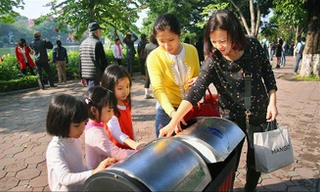 Hướng dẫn trẻ em bỏ rác đúng nơi quy định, dần hình thành văn hóa ứng xử nơi công cộng. Ảnh: Anh Tuấn.