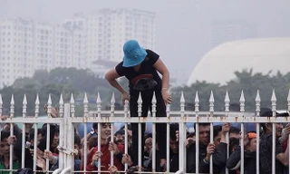Một CĐV bám chặt hàng rào mong tới lượt mua được vé bóng đá. Ảnh: VSI
