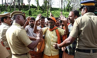 Cảnh sát ngăn chặn những tín đồ Hồi giáo tấn công phụ nữ vào đền Sabarimala. Ảnh: Getty Images.