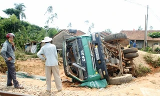 Sau cú tông, chiếc xe tải quay vòng rồi lật ngang bên đường