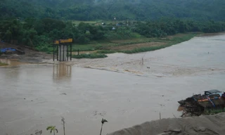 Nước lũ sông Hồng tràn về nhấn chìm toàn bộ tuyến đường từ bờ phía xã Vạn Hòa ra trụ mố giữa sông phục vụ thi công cầu Giang Đông bắc qua sông Hồng nối đôi bờ phía nam thành phố Lào Cai.