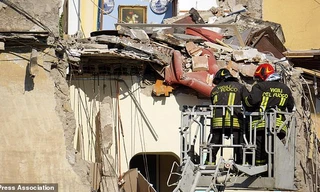 Hai lính cứu hỏa làm việc tại hiện trường vụ sập nhà. Ảnh: AP