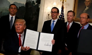 Tổng thống Mỹ Donald Trump ký văn bản ủy quyền cho Đại diện Thương mại Mỹ Robert Lighthizer để xem xét mở cuộc điều tra thương mại đối với Trung Quốc hôm 14/8. Ảnh: Reuters