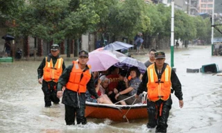 Đội cứu hộ hỗ trợ đưa người dân vùng lũ đến nơi an toàn. Ảnh: Reuters