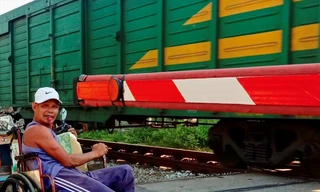 Dù tàn tật, đi lại bằng xe lăn nhưng ông Nguyễn Đức Toàn vẫn tự nguyện làm công việc gác chắn đường ngang nhiều năm nay