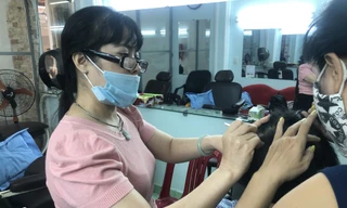 Chị Bùi Thị Tuyết, chủ tiệm Nhổ tóc bạc Tuyết (Bàn Cờ, quận 3, TPHCM) hành nghề “bới đen, tìm trắng” luôn có nguồn khách ruột ổn định Ảnh: U.P 