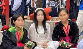 Giàng Thị Hờ (ngoài cùng bên phải) và Giàng Thu Hà (ngoài cùng bên trái) khoe ảnh gói bánh chưng cùng học sinh Hà Nội