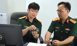 Thiếu tá, TS. Nguyễn Văn Hưng (bên trái), giảng viên Bộ môn Vũ khí - khoa Vũ khí trao đổi với đồng đội về tính năng của mẫu dao - súng tích hợp cho lực lượng đặc nhiệm