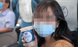 Hành khách trẻ thích thú với sản phẩm trà sữa trên chuyến bay. Ảnh: VNA