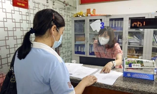 Cán bộ phường Trần Hưng Đạo (Hoàn Kiếm) tiếp dân, giải quyết thủ tục cấp giấy đi đường trong đợt giãn cách xã hội vừa qua. Ảnh: HOÀNG MẠNH THẮNG 