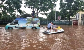 Đường phố ngập sâu, ô tô, xe máy không thể di chuyển, cư dân tại phố Mễ Trì lấy mô-tô nước ra đưa đón người thân