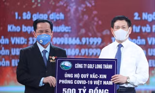 Anh hùng Lao động Lê Văn Kiểm, Chủ tịch Hội đồng quản trị Công ty CP Đầu tư và Kinh doanh Golf Long Thành (trái) trao tặng quỹ vắc-xin phòng, chống COVID-19 số tiền 500 tỷ đồng