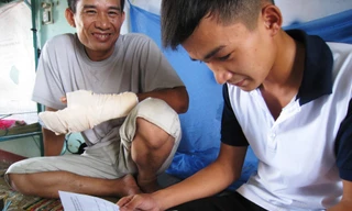 Ông Ơm và con trai xem lại kết quả bài thi môn cuối, trước khi rời Đà Nẵng. Ảnh: Nguyễn Huy