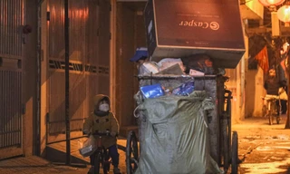 Bé trai 2 tuổi theo chân mẹ lao công đi gom rác trong đêm đông lạnh giá