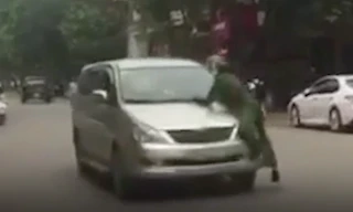 Lái xe bất chấp trên nắm ca pô có người vẫn nổ máy bỏ chạy - Ảnh: Cắt từ clip