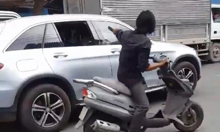 Nam thanh niên ngang nhiên dùng mã tấu chém vỡ kính chiếu hậu của hàng chục xe ô tô đang chạy trên đường tại TP.HCM. Ảnh cắp từ clip