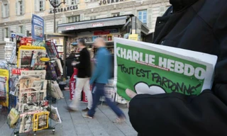 Một người cầm số mới nhất của tạp chí Charlie Hebdo. Ảnh: Reuters
