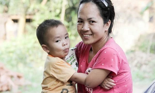 Người mẹ tật nguyền chăm con nhỏ bằng chân