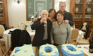 "Bố già" Di Maggio cầm ly uống rượu, chụp ảnh bên chiếc bánh kem hình số 100.