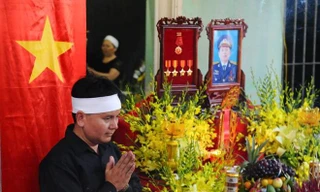 Anh Trần Minh Hùng, em trai liệt sĩ Trần Quang Khải đứng bên bàn thờ anh trai tại nhà riêng. Ản