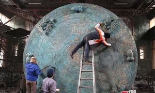 Các công nhân hoàn thiện phần họa tiết trên mặt chiếc trống đồng được cho là lớn nhất thế giới.