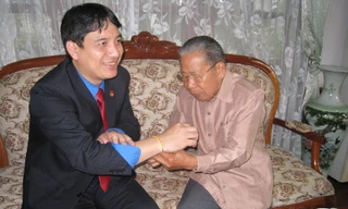 Ông Saman Vinhaket buộc chỉ cổ tay và chúc phúc cho anh Nguyễn Đắc Vinh