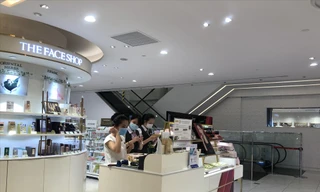 Nhân viên cửa hàng mỹ phẩm đeo khẩu trang tiếp khách