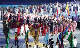 Tình nguyện viên nước chủ nhà rước quốc kỳ Việt Nam tiến vào sân VĐV Bung Karno trong lễ bế mạc Asiad 2018