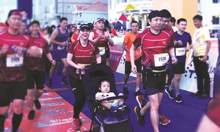 Gia đình chị Nguyễn Quỳnh Chi - Trần Phan Linh (38 tuổi) cùng con trai trên xe nôi xuất phát Ảnh: Xuân Tùng