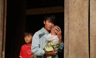 Vừ Bá Dải (chồng Y Râu 16 tuổi) với khuôn mặt non choẹt ôm cậu con trai vào lòng khi vừa trên rẫy về