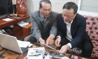 Ông Lê Ðình Rê (trái) chia sẻ những tư liệu quý với Chủ tịch UBND huyện Hoàng Sa Võ Ngọc Ðồng. Ảnh: Nguyễn Thành 