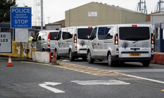 Xe phục vụ tang lễ xuất hiện tại khu vực phát hiện các thi thể Ảnh: Reuters