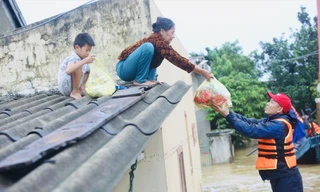 Bà Biên Thị An nhoài người nhận hàng cứu trợ 