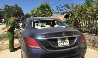 Chiếc xe sang để bên đường, kính sau và các cửa kính đều bị đập vỡ, trong xe có dấu vết máu