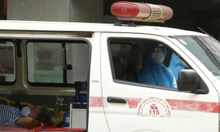 Nhân viên y tế đưa người nước ngoài vào khu xét nghiệm COVID-19 tại Bệnh viện Việt Pháp- Hà Nội sáng 26/3 Ảnh: Như Ý