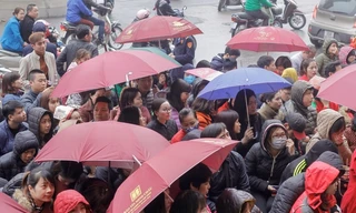 Mặc trời mưa gió, người dân vẫn kéo đến ngồi dưới mưa xếp hàng tại các cửa hàng vàng Hà Nội trong ngày vía Thần tài, mùng 10 Âm lịch.