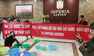 Bị cắt nước đầu năm, cư dân chung cư 203 Nguyễn Huy Tưởng mang băng rôn và xô chậu xuống sảnh phản đối.