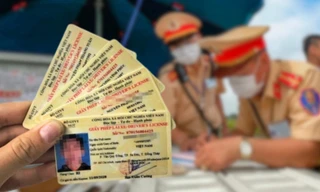 Người dân kiểm tra lại hồ sơ trước khi vào làm thủ tục xin cấp, đổi lại GPLX