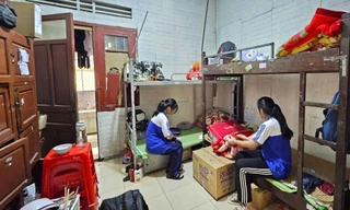 Các em học sinh ở trong khu ký túc xá chật chội, quần áo giăng kín lối đi