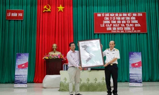 Ông Dương Văn Quynh - giám đốc Trung tâm triển lãm VHNT Việt Nam trao tặng bản sao thu nhỏ tấm bản đồ kỷ lục cho ông Nguyễn Văn Thắng- chính ủy lữ đoàn 146, vùng 4 hải quân.