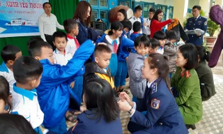 Các nữ chiến sĩ Vùng cảnh sát biển 2 trao áo ấm và quà cho học sinh có hoàn cảnh khó khăn, là con em của đồng bào dân tộc Cor. 