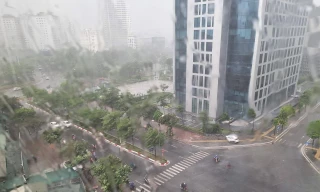 Mưa to gió lớn khiến người đi xe máy không thể di chuyển ở đoạn đường gần khu Đại sứ quán Mỹ thuê