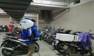 Công nhân phun thuốc khử khuẩn tại khu vực để xe