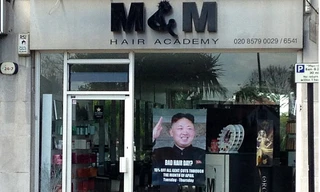 Tấm poster khuyến mại in hình lãnh đạo Triều Tiên Kim Jong Un treo trước cửa hàng tạo mẫu tóc M&M