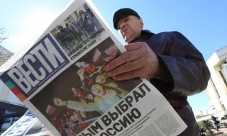 Một người đàn ông đọc tờ báo có tựa đề "Crimea chọn Nga" ở Simferopol, Crimea