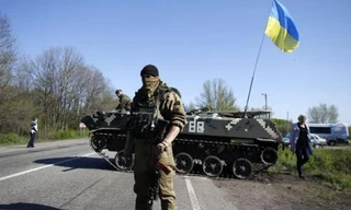 Một lính Ukraine đứng trước xe tăng ở trạm kiểm soát tại làng Malinivka, Slaviansk, đông Ukraine 