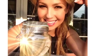 Nữ ca sỹ xinh đẹp tươi cười bên cạnh chiếc lọ thủy tinh đựng 2 xương sườn của mình