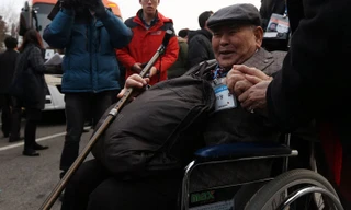 Một cụ ông ngồi xe lăn chuẩn bị cho cuộc đoàn tụ