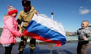 Một người đàn ông cùng 2 em nhỏ cầm cờ Nga ở Sevastopol, Crimea